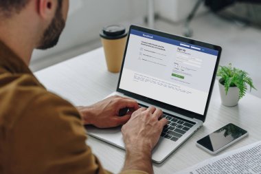 ekranda facebook web sitesi ile dizüstü bilgisayar kullanarak adam kırpılmış görünümü 