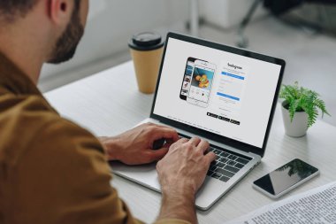 ekranda instagram web sitesi ile dizüstü bilgisayar kullanarak adam kırpılmış görünümü 