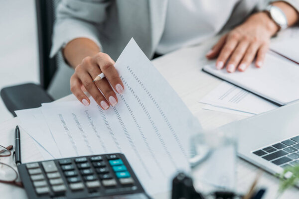 cropped view of woman doing paperwork and holding pencil 