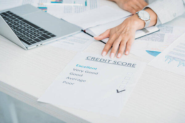 cropped view of woman showing credit score at office 