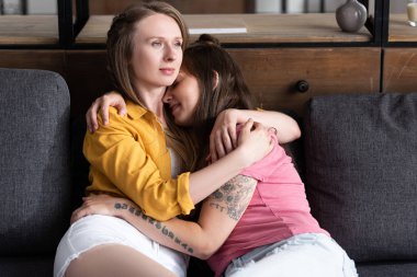 oturma odasında kanepede otururken kucaklayan iki güzel Lezbiyenler