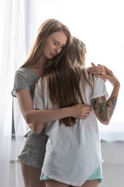 yatak odasında kucaklayan t-shirt iki gülümseyen lezbiyenler