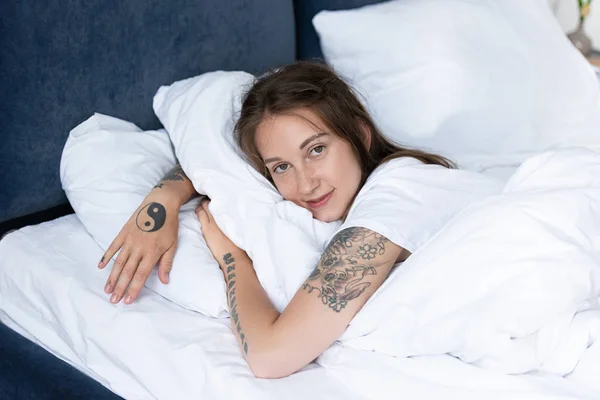 Chica Tatuada Atractiva Acostada Cama Mirando Cámara Dormitorio —  Fotos de Stock