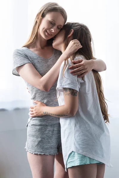 yatak odasında kucaklayan t-shirt iki gülümseyen lezbiyenler