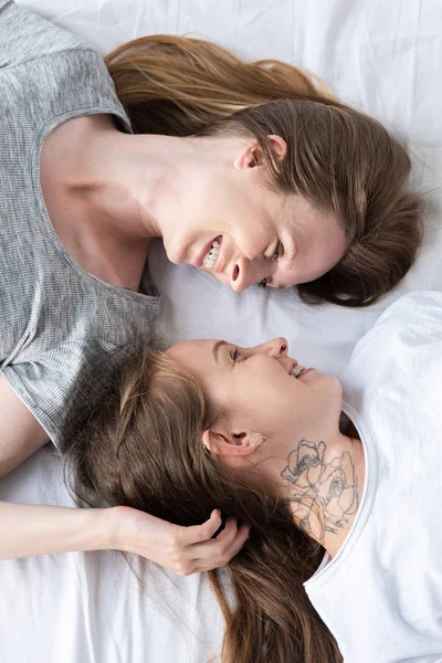 Pohled Dva Usmívající Lesbičky Kteří Sebe Dívají Zatímco Leží Posteli — Stock fotografie