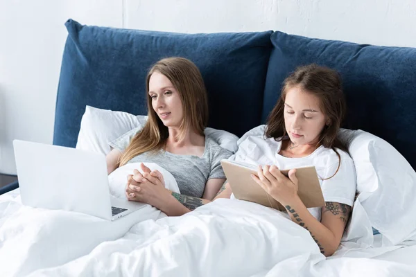 Two Lesbians Laptop Book Holding Hands While Lying Blanket Bed — Stock Photo, Image