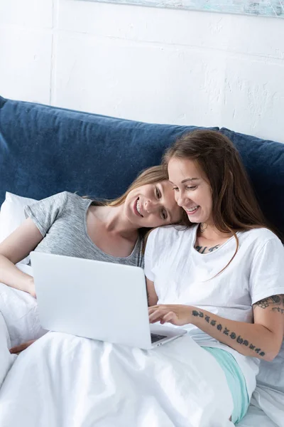 Dos Lesbianas Sonrientes Abrazando Mientras Usa Ordenador Portátil Cama Por — Foto de Stock