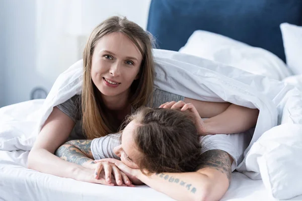 Två Leende Lesbiska Omfamna Medan Liggande Filt Sängen — Stockfoto