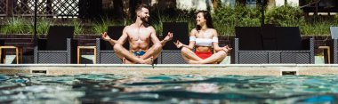 yüzme havuzu yakınında meditasyon mutlu kadın ve yakışıklı adam panoramik çekim  