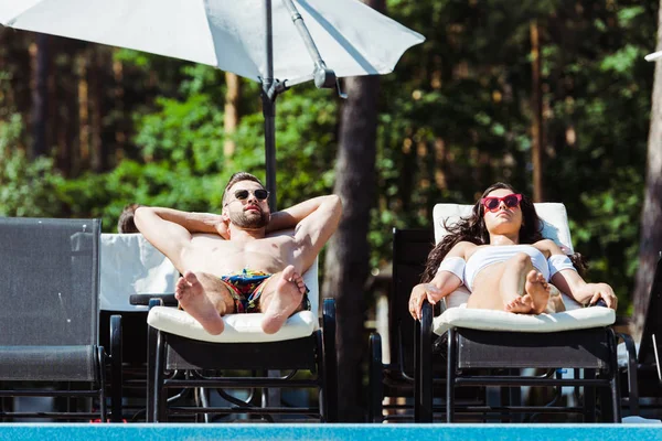 Schöner Mann Und Schöne Frau Mit Sonnenbrille Liegen Auf Liegestühlen — Stockfoto
