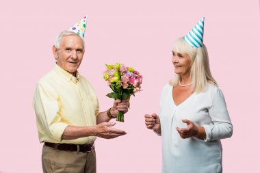 pembe izole neşeli karısı yakınında çiçek tutan parti kap mutlu üst düzey adam 