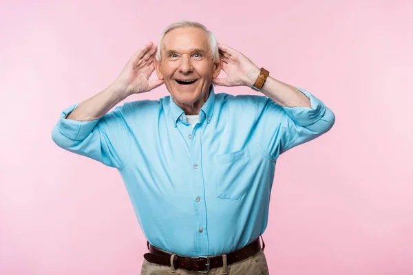 Cheerful Senior Man Touching Ears Smiling While Standing Pink — Stock Photo, Image