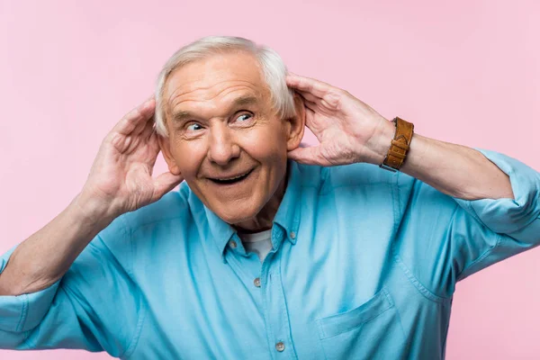快乐的老人触摸耳朵和微笑孤立在粉红色 — 图库照片