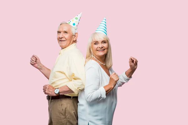 Wesoły Starszy Mąż Żona Party Caps Wskazując Izolowane Różowy — Zdjęcie stockowe