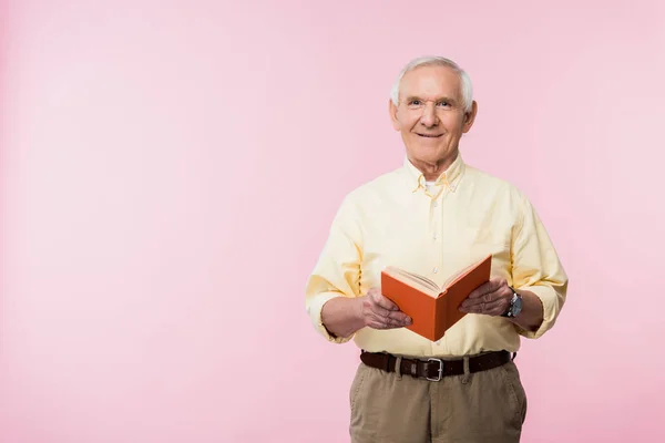 Positieve Gepensioneerde Man Holding Boek Glimlachend Roze — Stockfoto