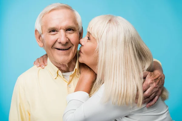 Retired Woman Kissing Cheek Cheerful Man Grey Hair Blue — Stock Photo, Image