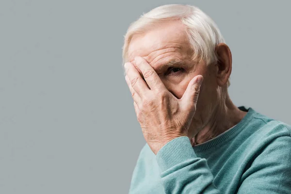 Upprörd Pensionerad Man Täcker Ansiktet Och Tittar Kameran Isolerad Grå — Stockfoto