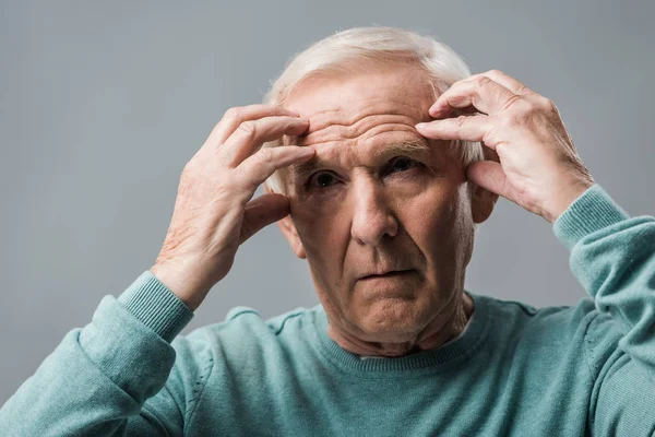 精疲力竭的退休男子看着相机和触摸头隔离在灰色 — 图库照片