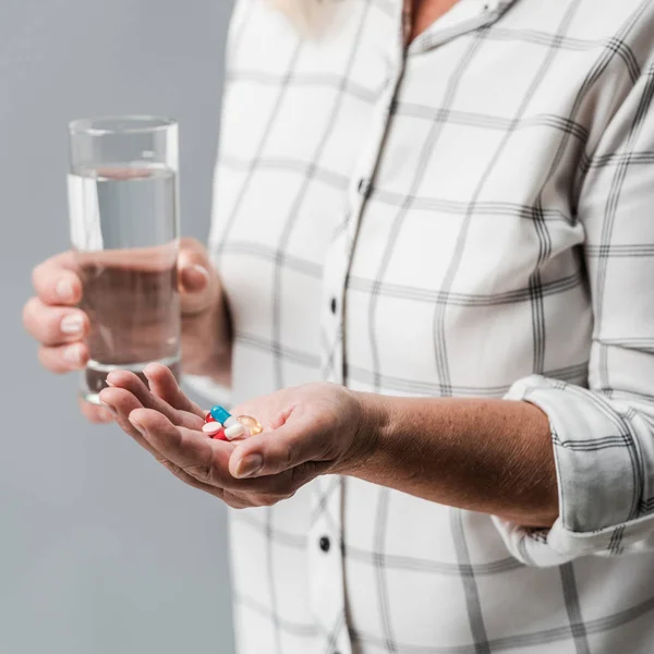 Selectieve Focus Van Senior Vrouw Houdt Pillen Glas Water Geïsoleerd — Stockfoto