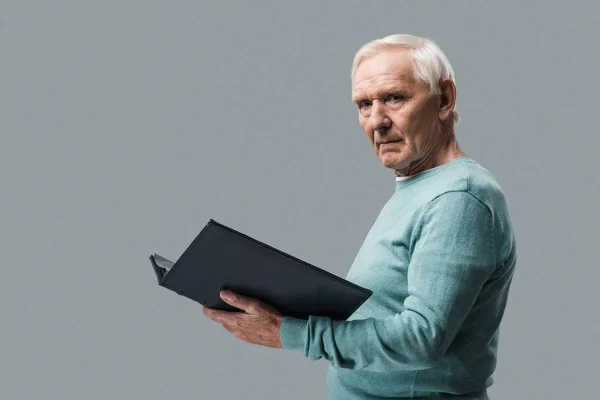 Boos Gepensioneerde Man Met Grijze Haren Houden Fotoalbum Geïsoleerd Grijs — Stockfoto