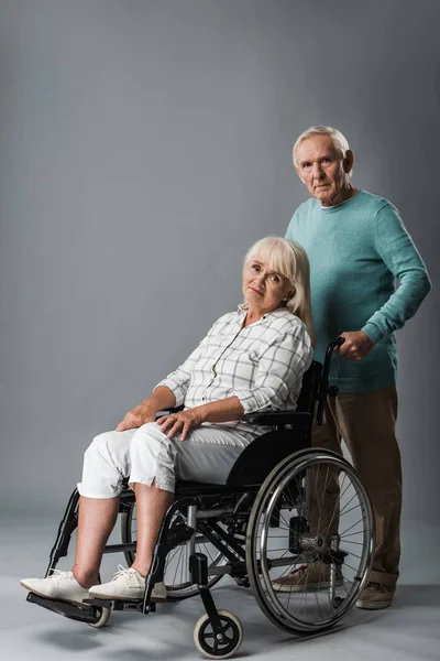 Upprörd Man Stående Nära Funktionshindrade Pensionerad Hustru Sittande Rullstol Grå — Stockfoto