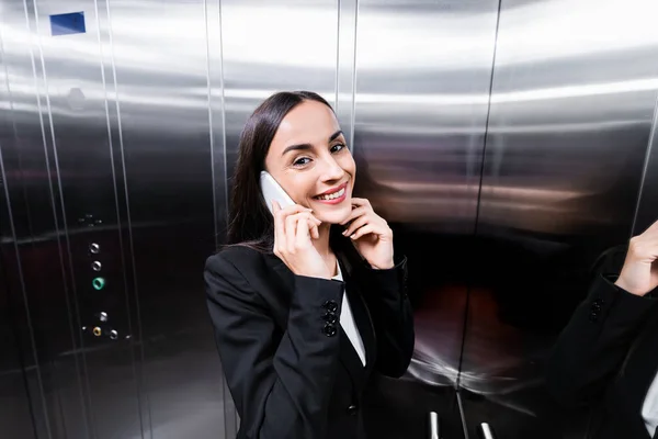 Alegre Mujer Negocios Hablando Smartphone Ascensor Sonriendo Cámara — Foto de Stock