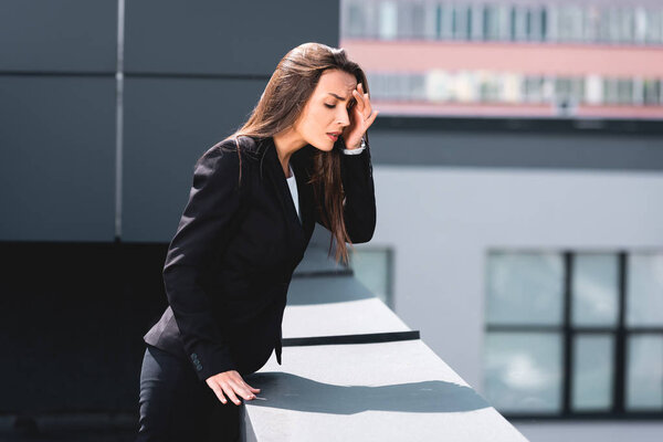 anxious businesswoman, suffering from acrophobia, standing on rooftop and looking down