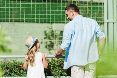 neşeli baba ve kızı hayvanat bahçesinde birbirlerine bakarak seçici odak 