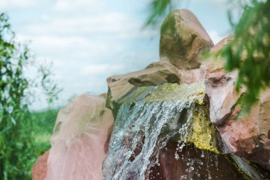 selective focus of drops of water drops near rocks and waterfall  clipart