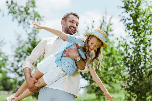 Fröhlicher Vater Hält Glückliche Tochter Mit Strohhut Den Armen — Stockfoto