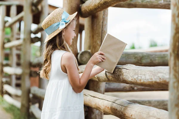 Selective Focus Cute Kid Holding Book Wooden Fence — Stock Photo, Image