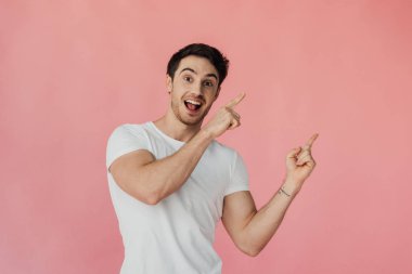 pembe izole parmakları ile işaret beyaz t-shirt heyecanlı kaslı adam