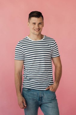 pembe izole kamera bakarak cebinde el ile çizgili t-shirt gülümseyen adam
