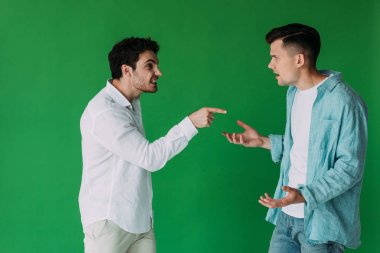 two men in shirts quarreling and screaming at each other isolated on green clipart