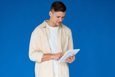 mavi izole dijital tablet kullanarak gömlek genç adam