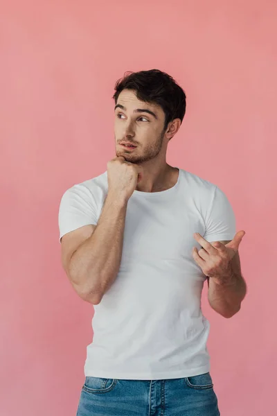 沉思肌肉男子在白色T恤支撑脸与拳头和依靠手指隔离在粉红色 — 图库照片