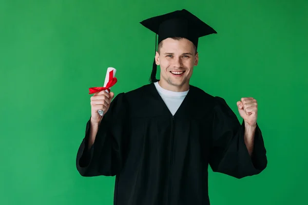 Estudiante Sonriente Gorra Académica Sosteniendo Diploma Con Cinta Roja Mostrando —  Fotos de Stock