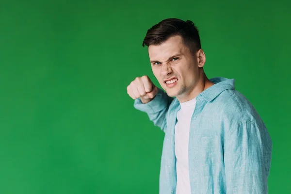 Joven Enojado Camisa Sosteniendo Puño Mirando Cámara Aislada Verde — Foto de Stock