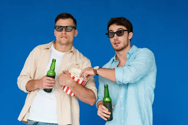 两个朋友在3D眼镜拿着啤酒和爆米花瓶隔离在蓝色 — 图库照片