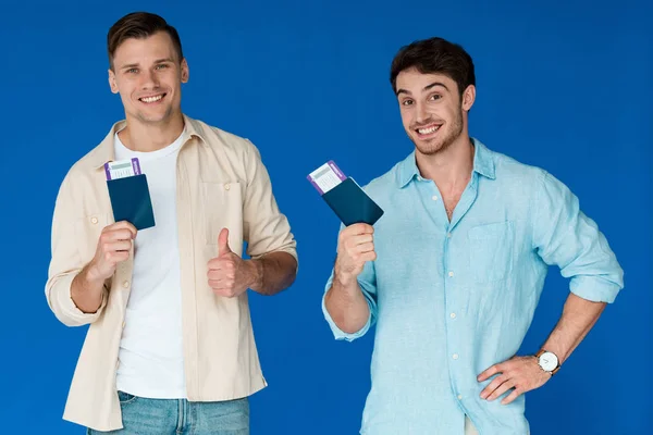 Dva Usmívající Turisté Kteří Drží Pasy Letenkami Ukazují Palec Modré — Stock fotografie