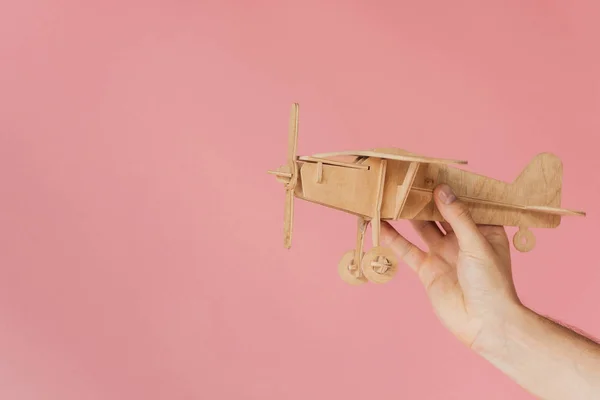 Bijgesneden Beeld Van Man Holding Houten Speelgoed Vliegtuig Geïsoleerd Roze — Stockfoto