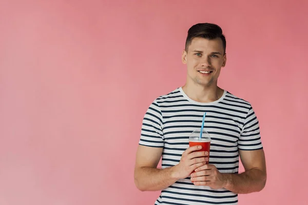 Вид Улыбающегося Молодого Человека Полосатой Футболке Держащего Напиток Изолированный Розовом — стоковое фото