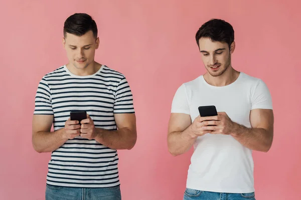 Vista Frontal Dos Hombres Sonrientes Usando Teléfonos Inteligentes Aislados Rosa — Foto de Stock
