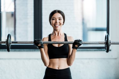 neşeli kadın spor salonunda halter ile çalışma 