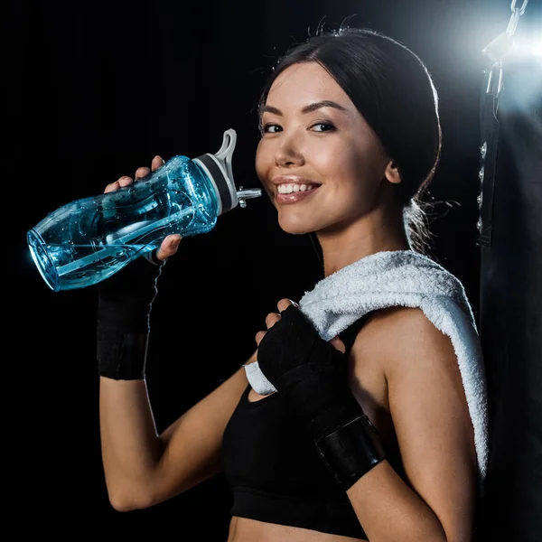 Menina Alegre Segurando Garrafa Esporte Sorrindo Isolado Preto — Fotografia de Stock