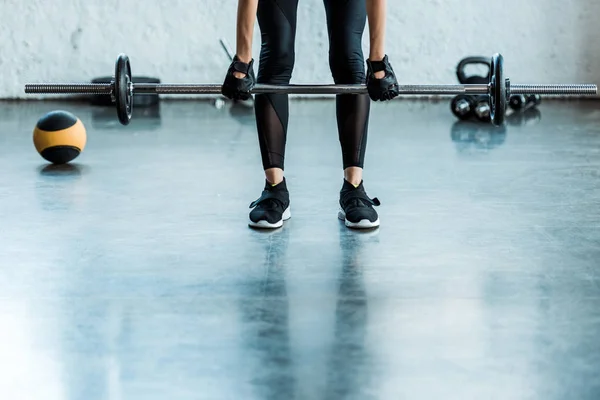 穿着运动服的妇女在健身房用杠铃锻炼的裁剪视图 — 图库照片