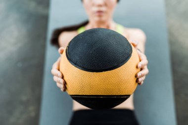 fitness mat üzerinde yatarken top tutan kadının seçici odak 
