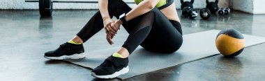 topa yakın fitness mat üzerinde oturan kadının panoramik atış 