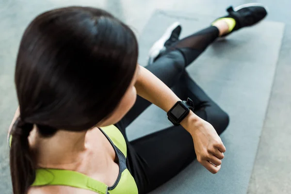 Enfoque Selectivo Mujer Mirando Reloj Fitness Mientras Está Sentado Estera — Foto de Stock