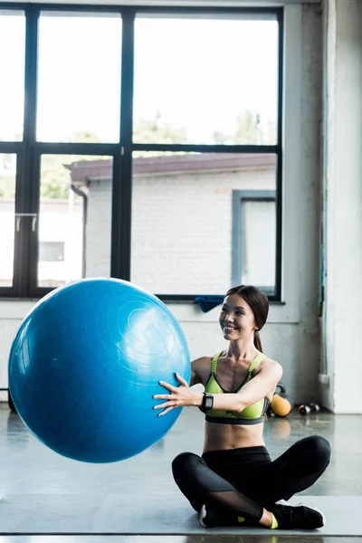 Gadis Ceria Memegang Bola Kebugaran Biru Sambil Duduk Atas Tikar — Stok Foto